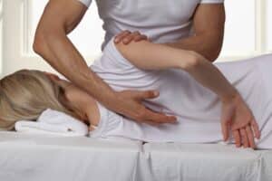 Woman having chiropractic back adjustment. Osteopathy, Alternative medicine, pain relief concept. Physiotherapy, sport injury rehabilitation